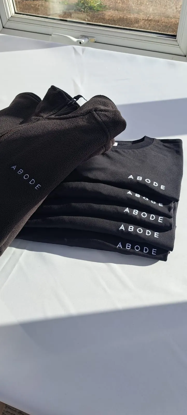 Abode interior designers logo on a t-shirt