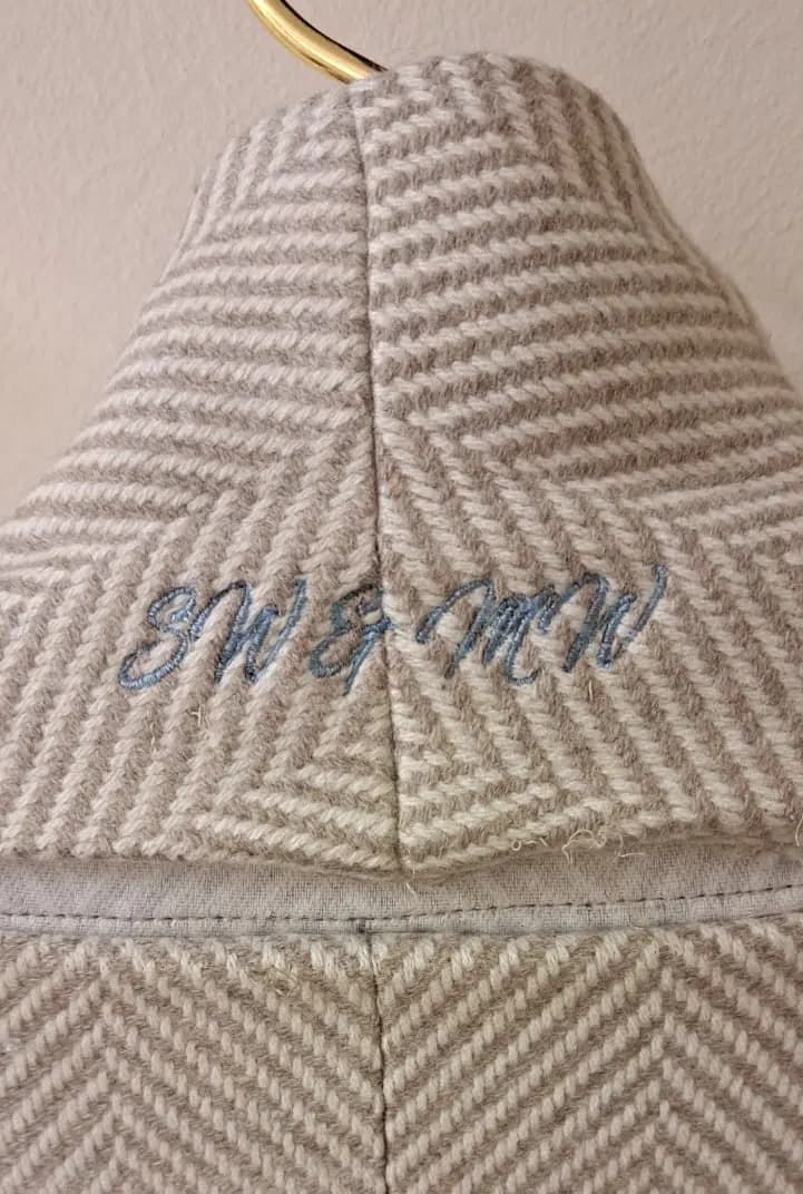 Couple's initials stitched in blue under a jacket collar