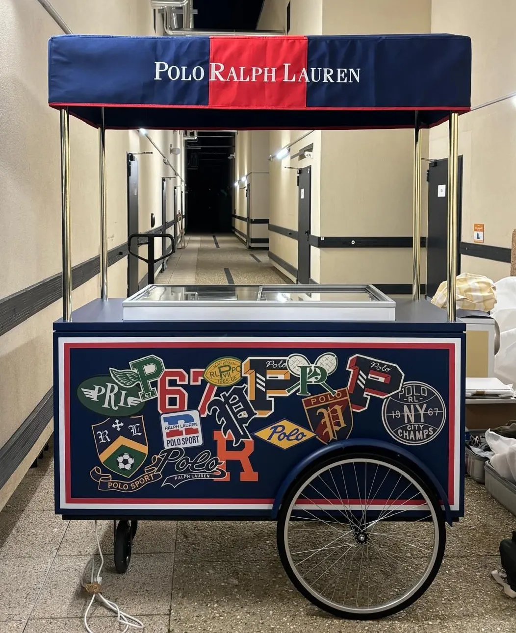 Polo Ralph Lauren branded ice cream cart with an embroidered canopy and side panel
