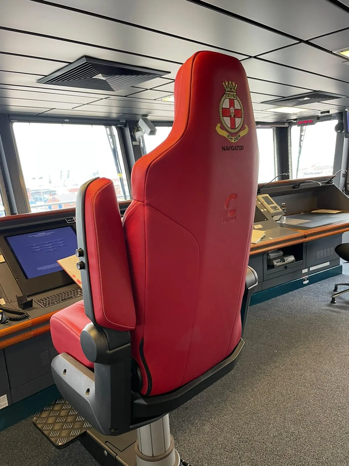 Red leather ship's chair embroidered 'Navigator' with a naval crest