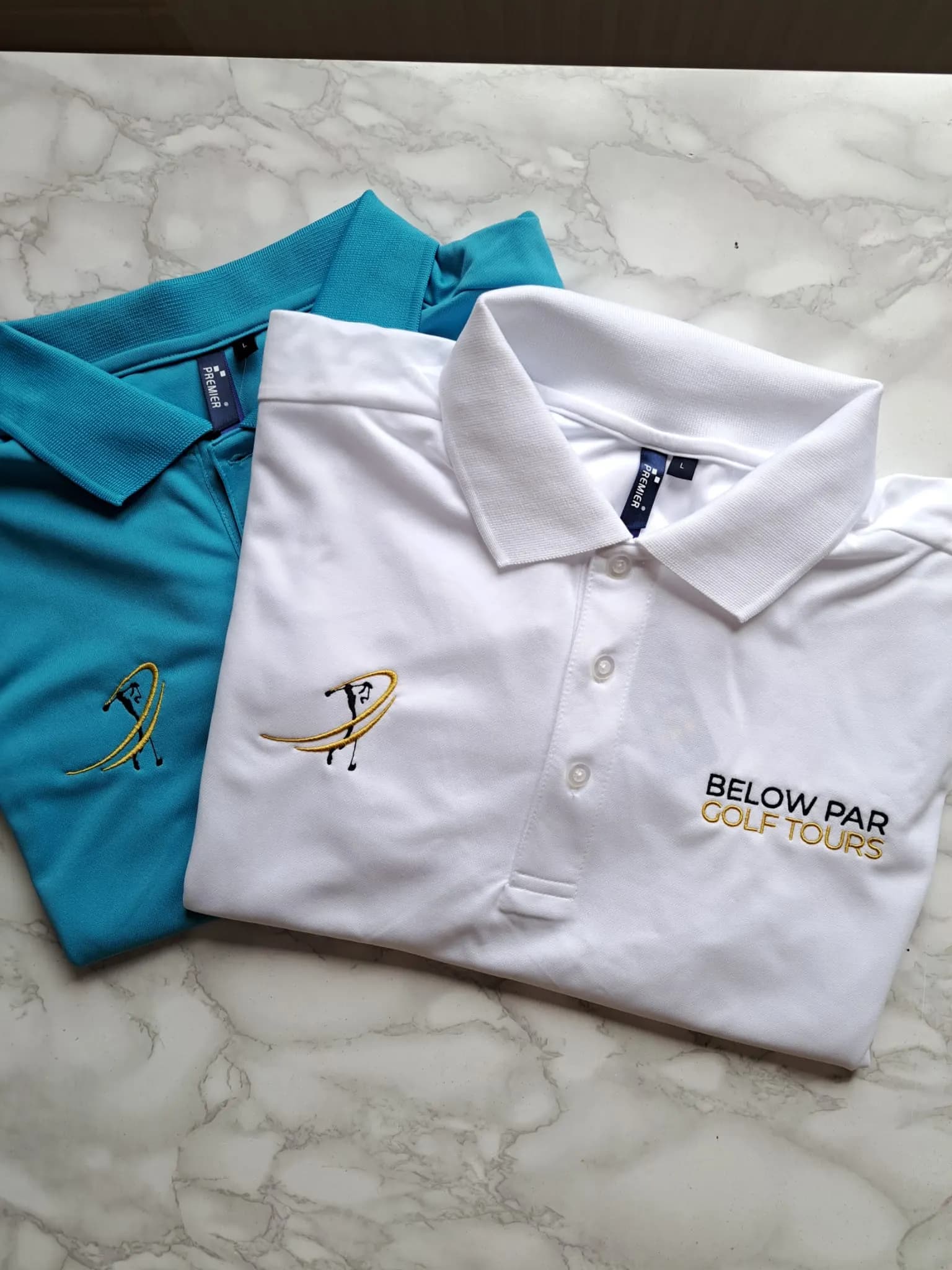 Teal and white polo shirts embroidered with the Below Par Golf Tours logo