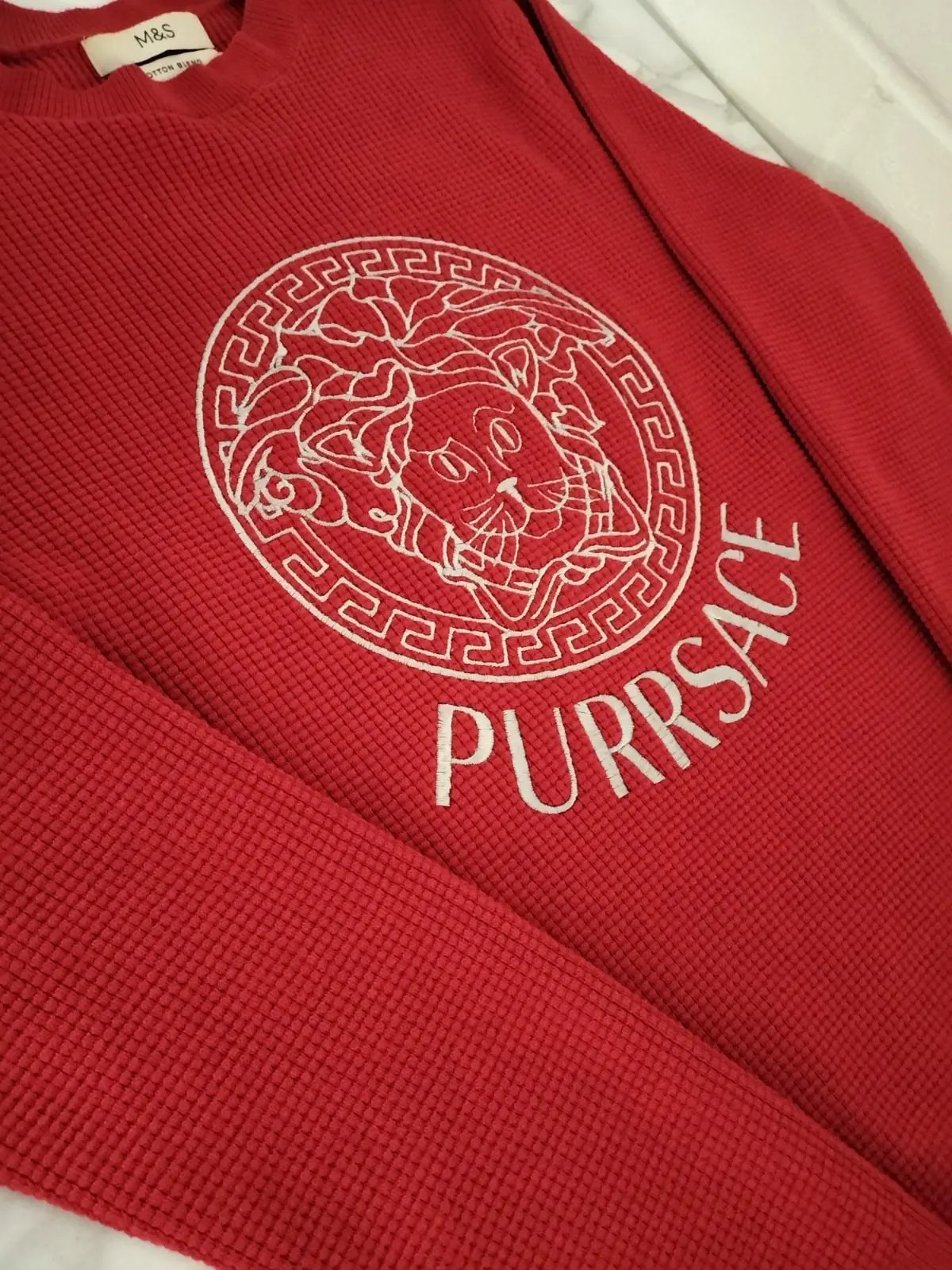 Red knitted pet jumper embroidered with a playful 'Purrsace' logo